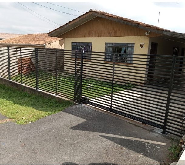 Portão moderno em aço instalado em fachada residencial