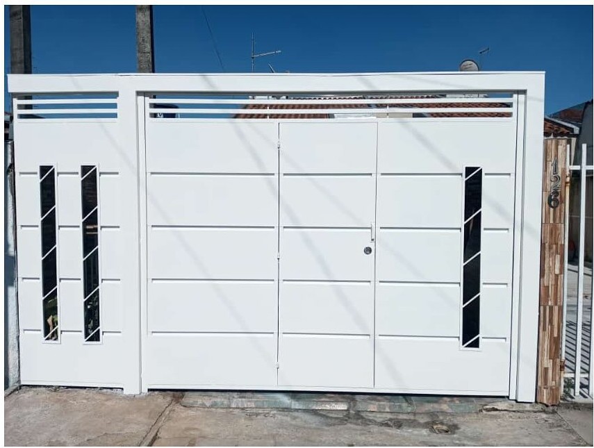 Portão basculante branco instalado em residência