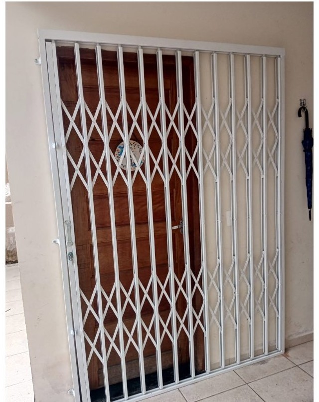 Grade pantográfica instalada em porta de residência